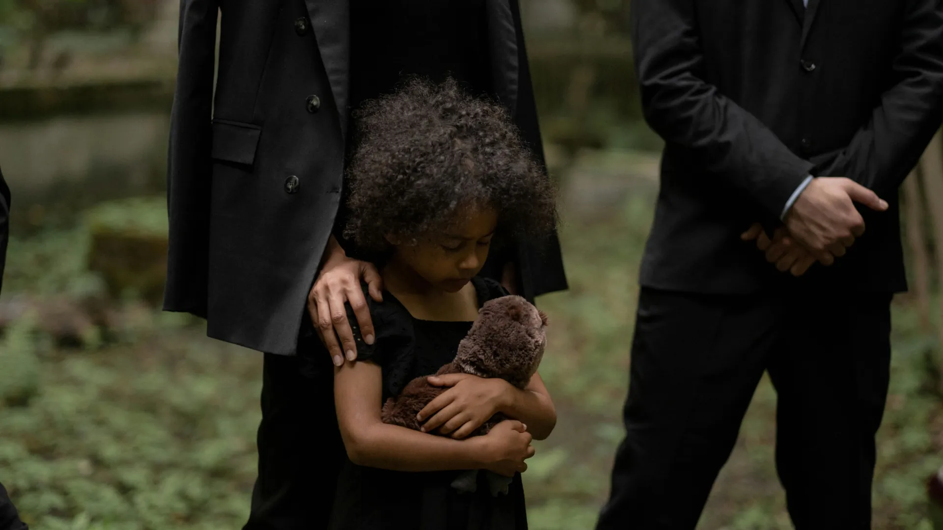 A little girl mourns the loss of a much loved family member. She is visibly upset.