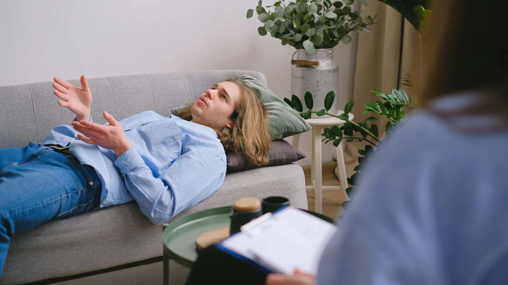 A young man discussing his problems during a hypnotherapy session.
